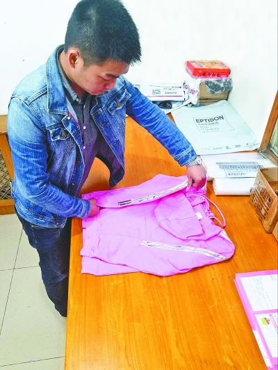 昨天，叶林在整理女装样品 记者李芳 通讯员侯庆 摄